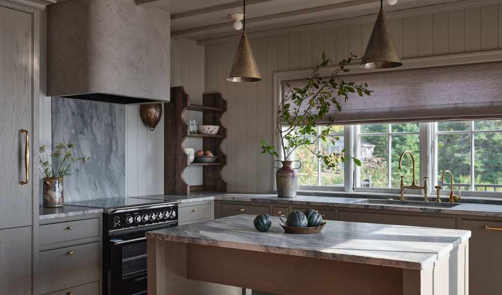 an earthy brown grey small kitchen with blue veined marble countertops and terracotta floor tiles