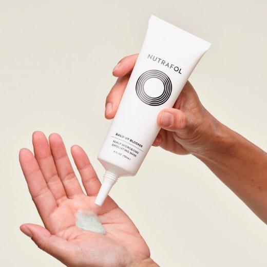 Image of hand model applying Nutrafol Build Up Blocker onto their hand