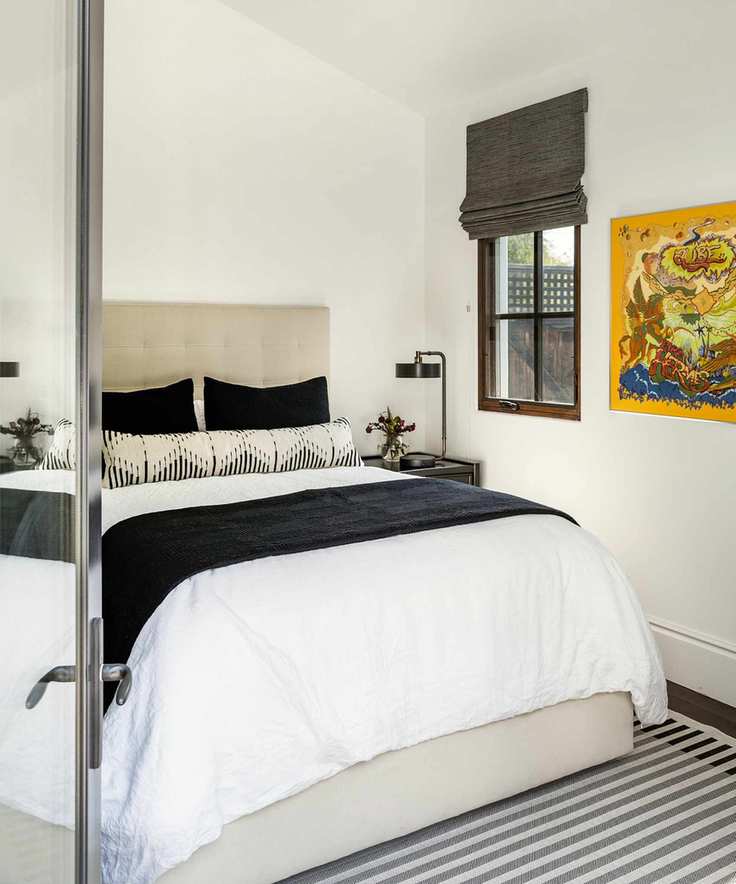 Monochrome bedroom with bright yellow artwork