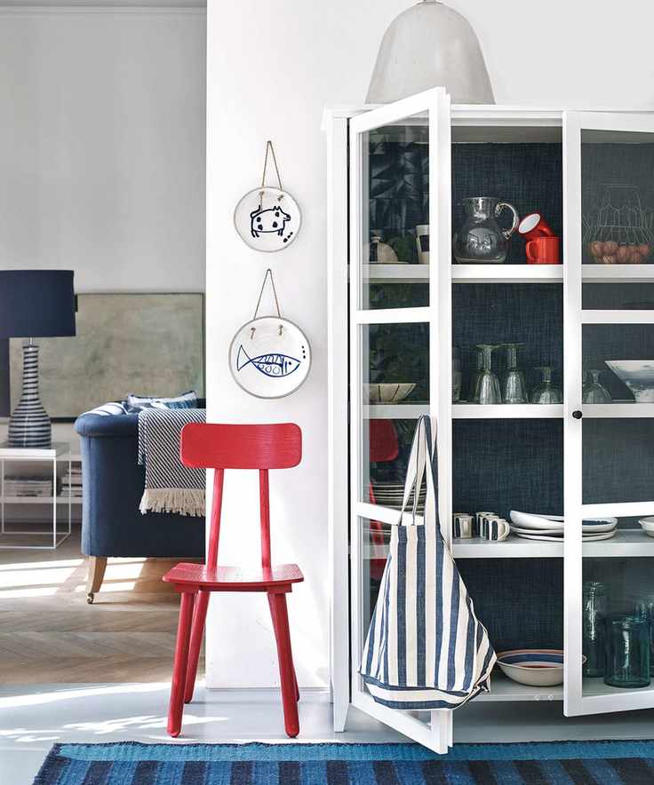 White glass-fronted dresser showcasing colorful accessories