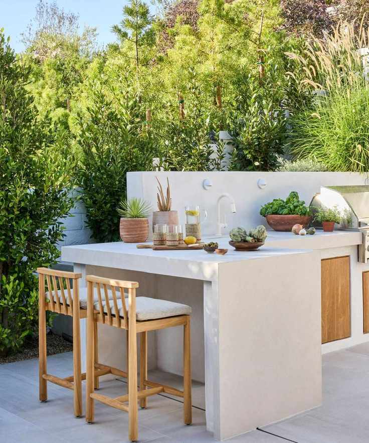Stone outdoor kitchen with wooden cabinets and bar seating with wooden stools
