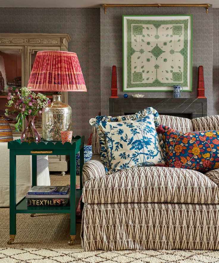 Sitting room with a sofa in a fabric by Sarah Vanrenen, framed antique wall fabric and table lamp with vintage sari lampshade