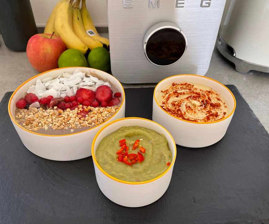 Smoothie, guacamole, and hummus in front of the Smeg Professional blender