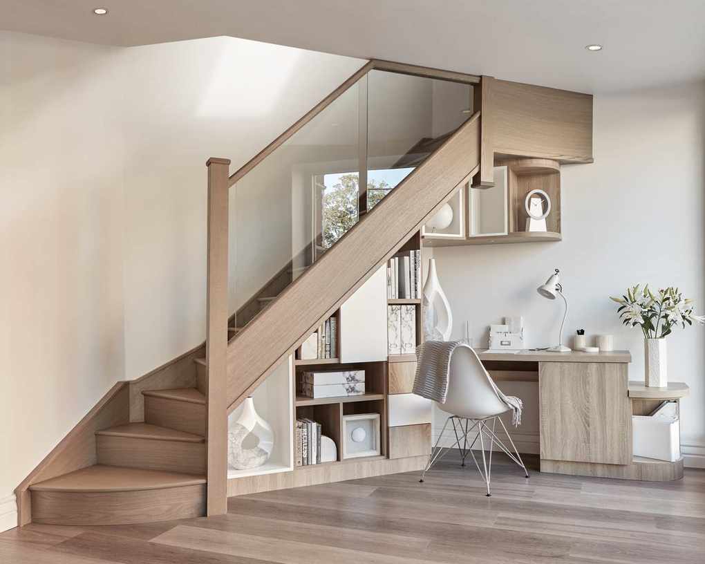 An under stairs ideas with built-in desk and shelving unit under pale wood staircase