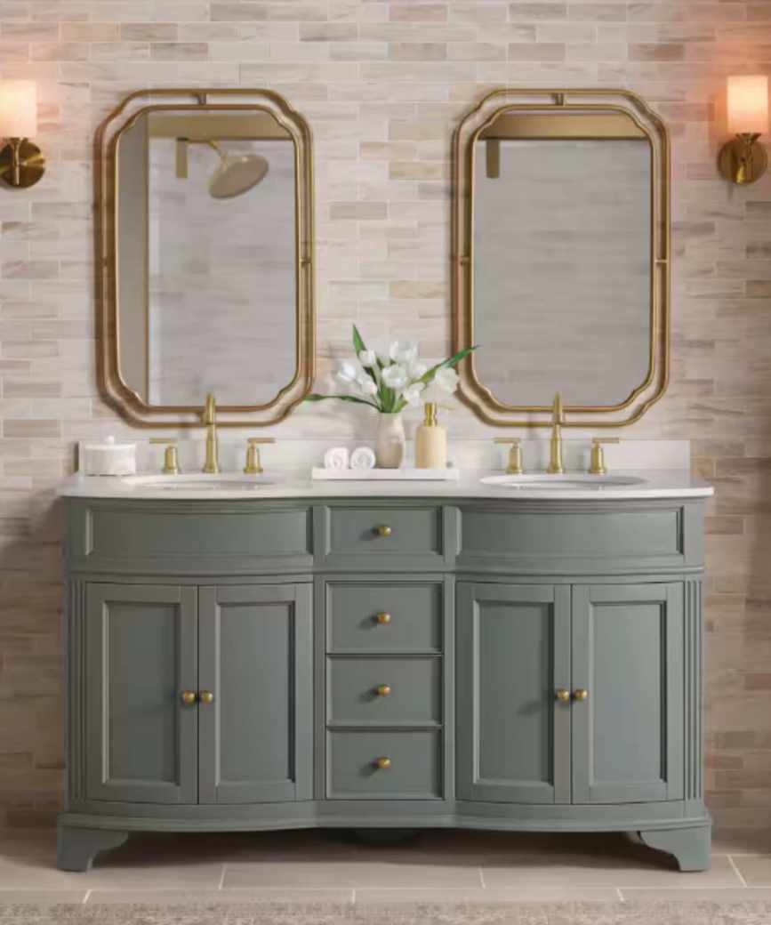 A gray bathroom vanity with a white countertop paired with gold faucets and gold mirrors