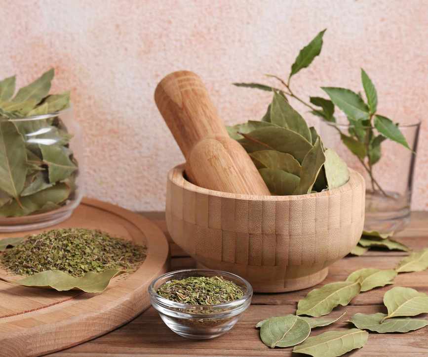 Bay leaves being crushed with a mortar and pestle