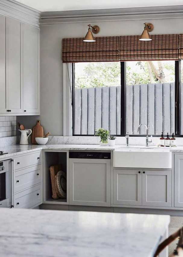 An example of how much does it cost to have kitchen cabinets painted showing a white kitchen with marble worktops and a white Belfast sink