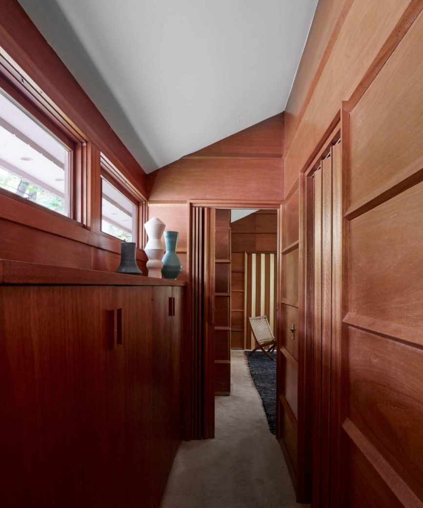 Wood panelled hallway with vases and cabinets