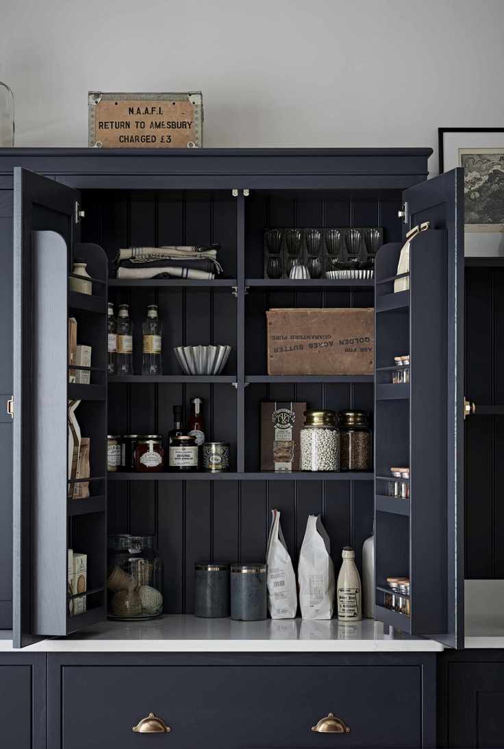 dark blue kitchen with cabinet on countertop with open doors