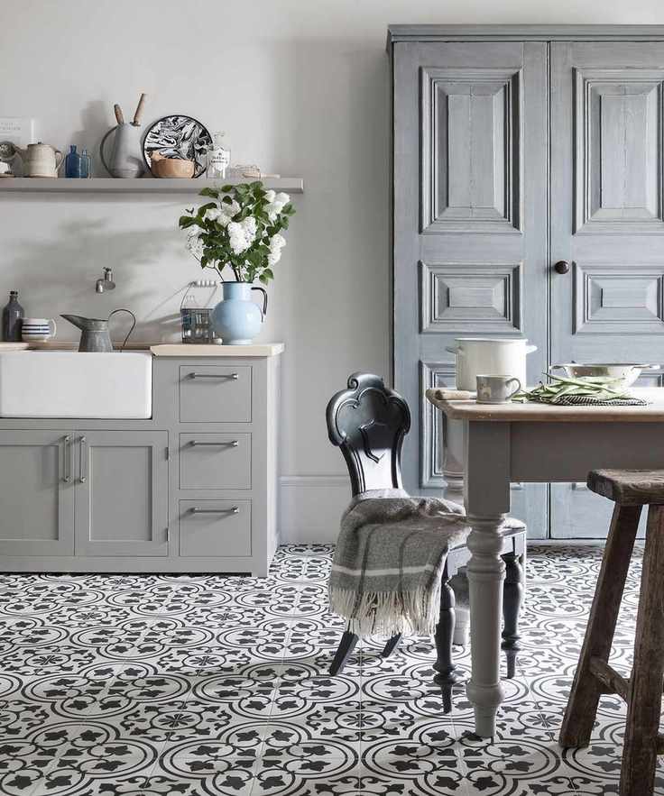Dining-kitchen space with cuban, black and white floor tiles, traditional wooden dining table with gray painted frame