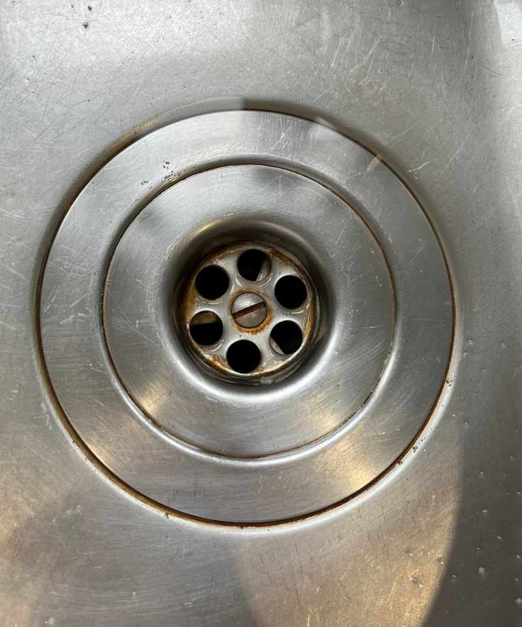Close up of stainless steel sink drain with tea and coffee stains