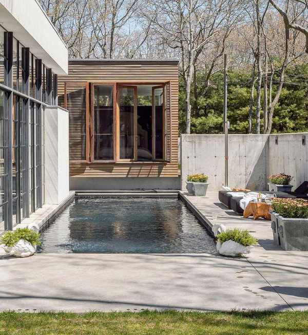 A small pool area next to glass french doors and wood slats