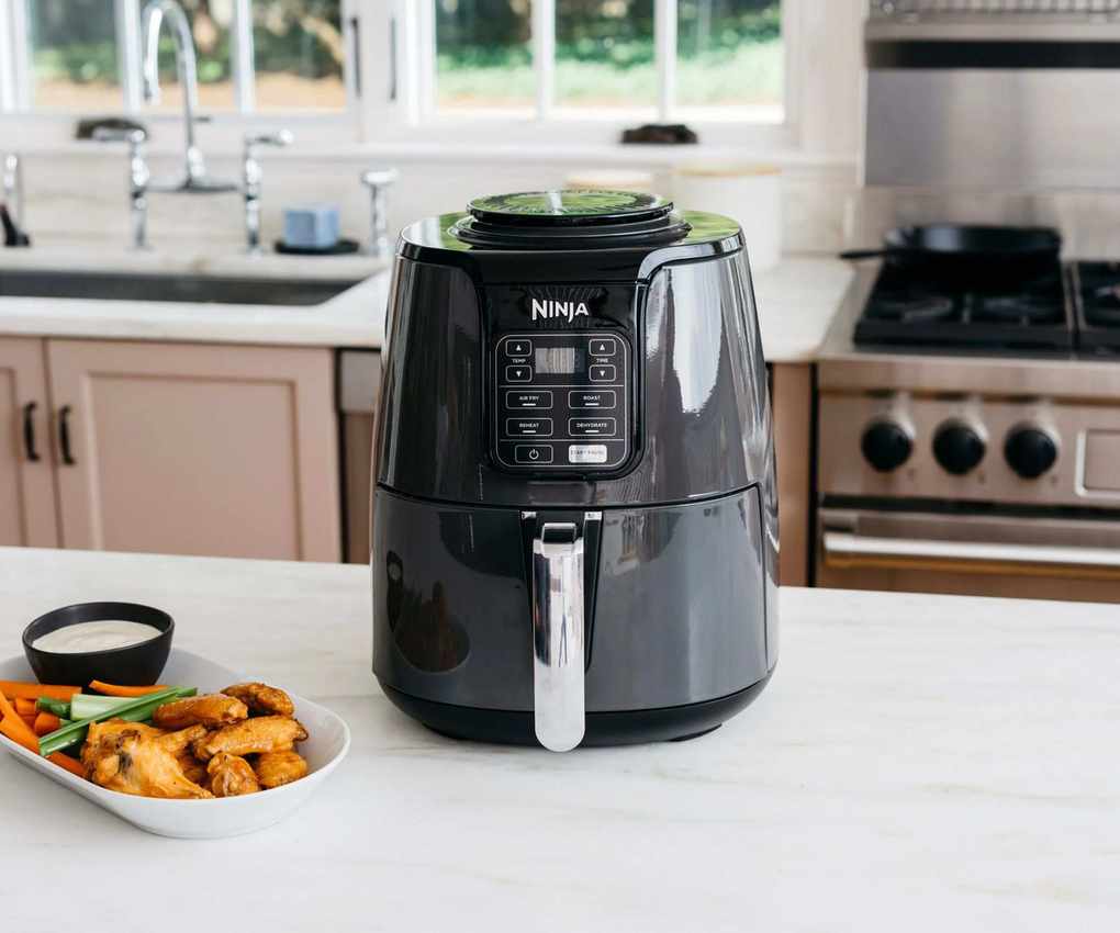 Ninja Air Fryer on a kitchen counter with chicken nuggets and vegetables