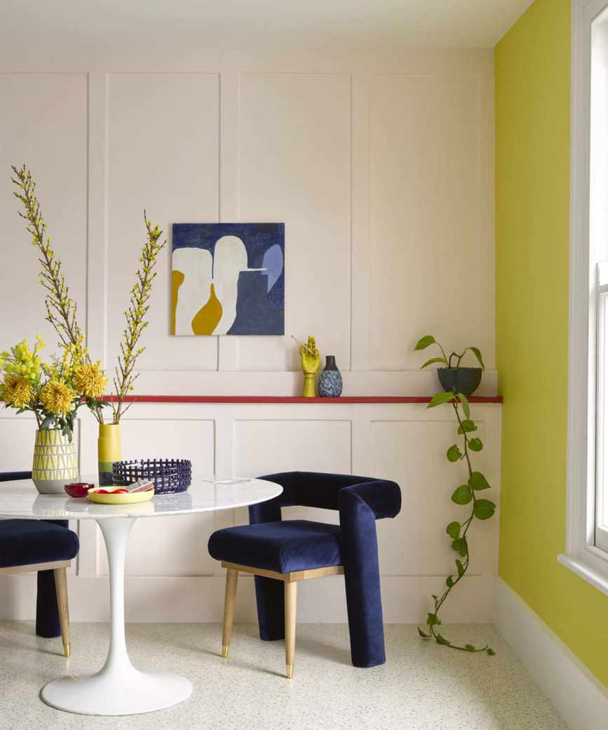 Dining room with a vibrant yellow feature wall and contrasting decor