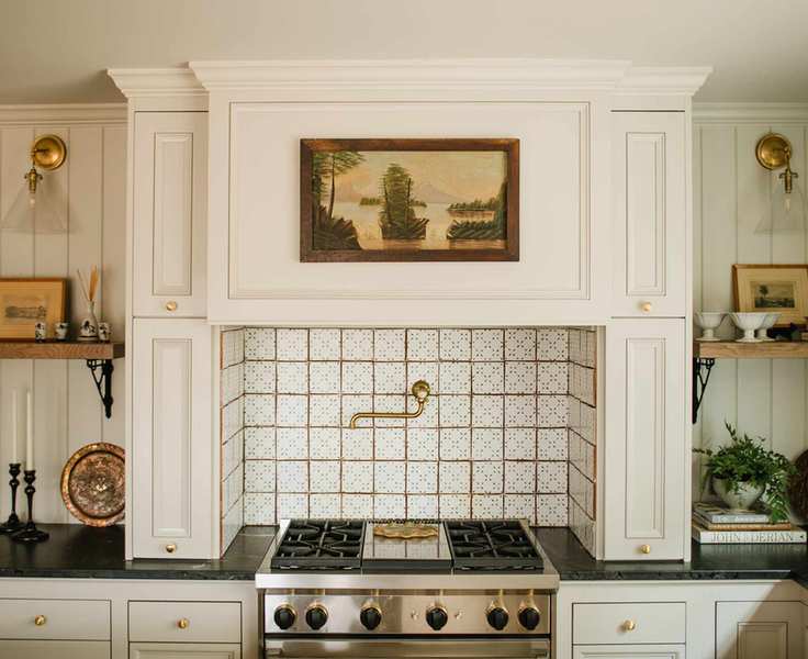A white farmhouse-style kitchen with a terracotta tiled backsplash behind the oven, illustrating white kitchen backsplash ideas.