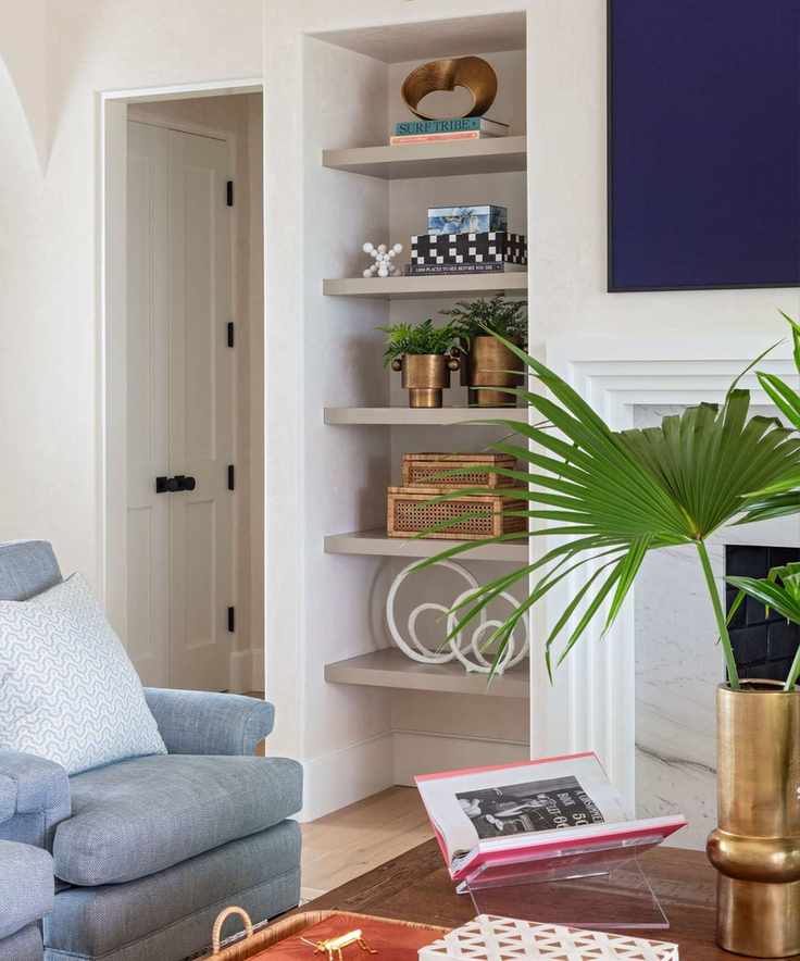 A living room with a tall bookshelf and a coffee table with a vignette