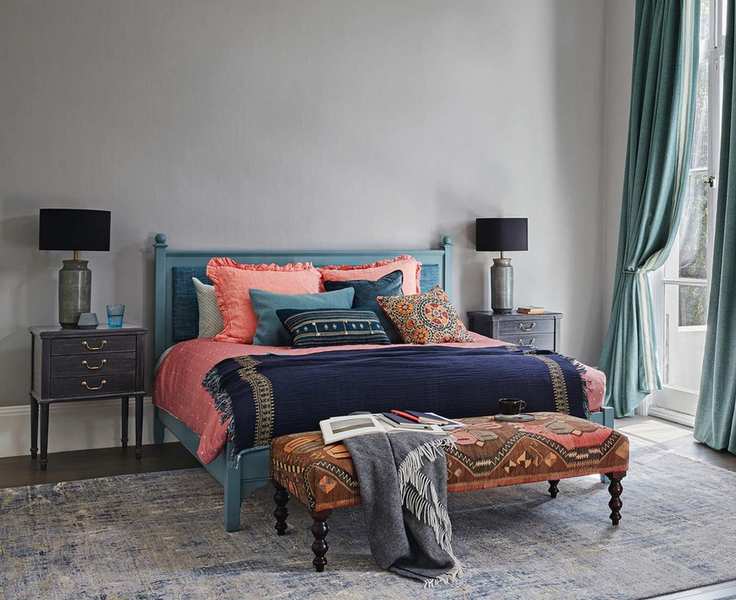 A grey bedroom with colorful bedding
