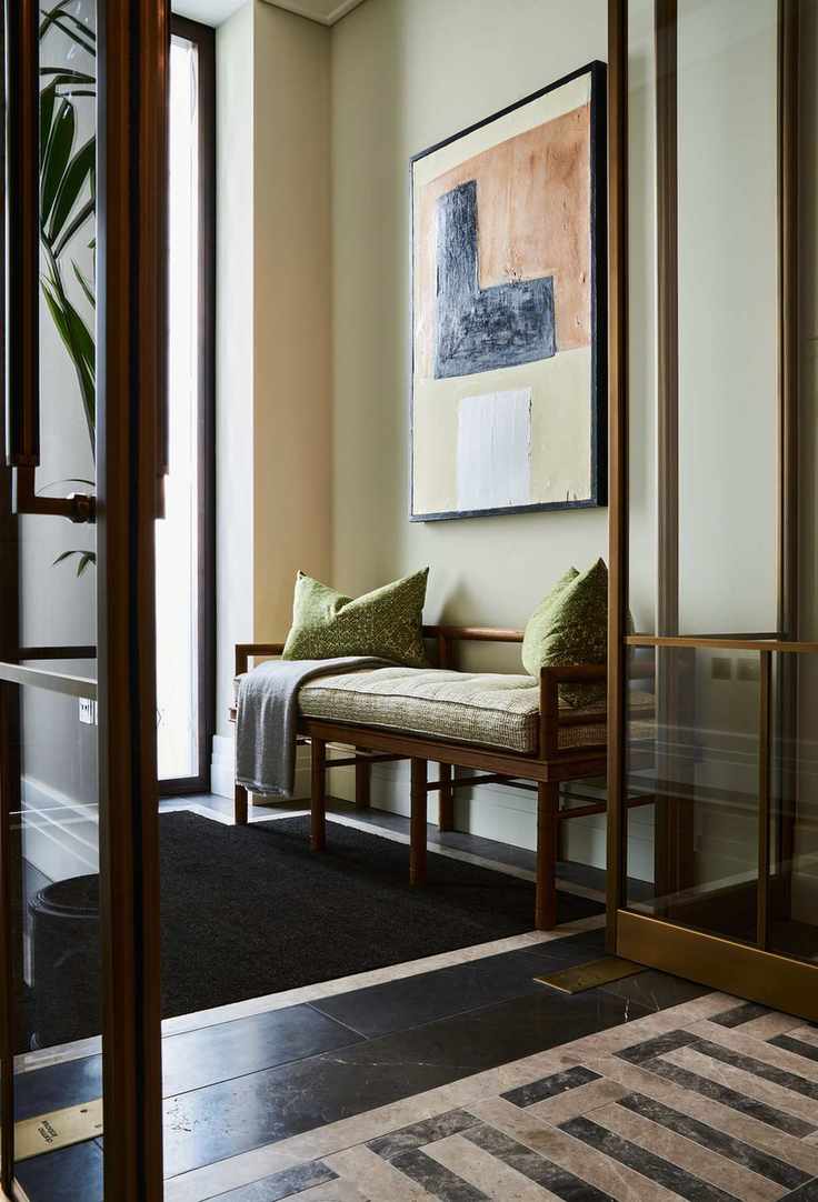 entryway with bench, artwork, cushions, cream walls