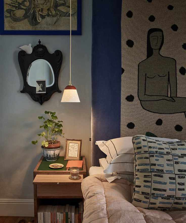 A maximalist bedroom with a side table and small lamp