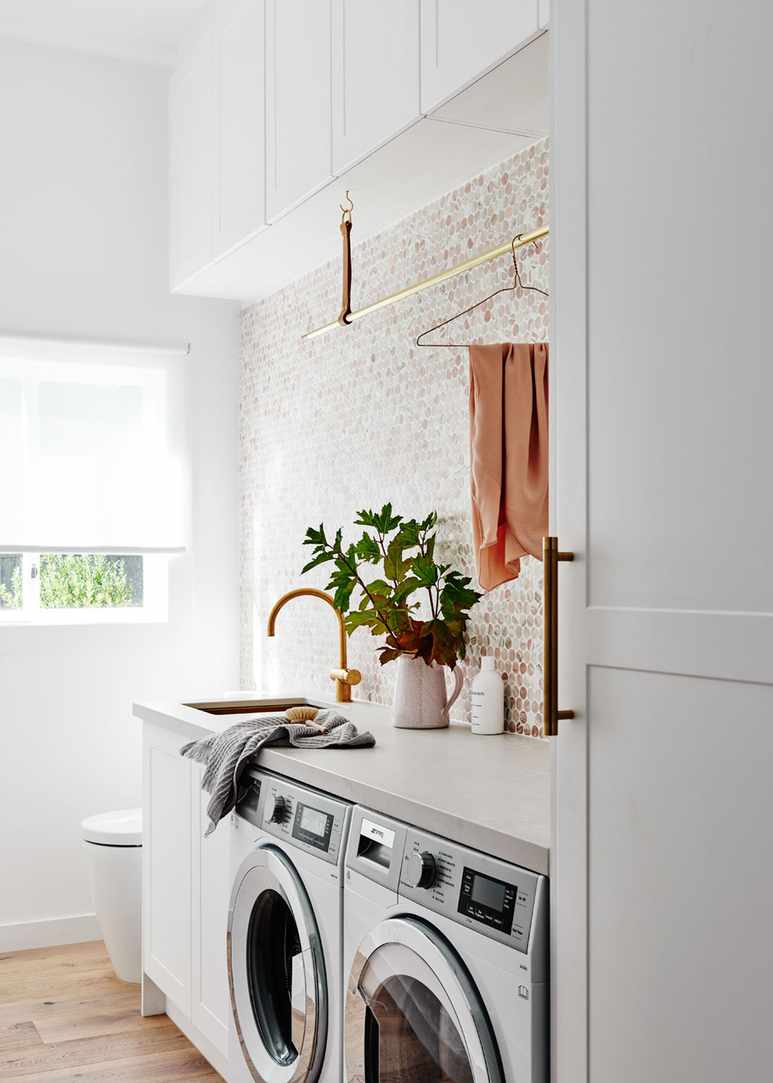 Laundry incorporated into a stylish bathroom with mosaic tiles.