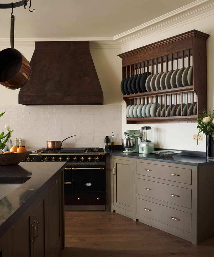 Wooden wall-mounted plate rack in a traditional style olive green kitchen