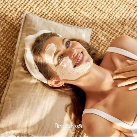 Woman with Natura Bisse Skincare products on