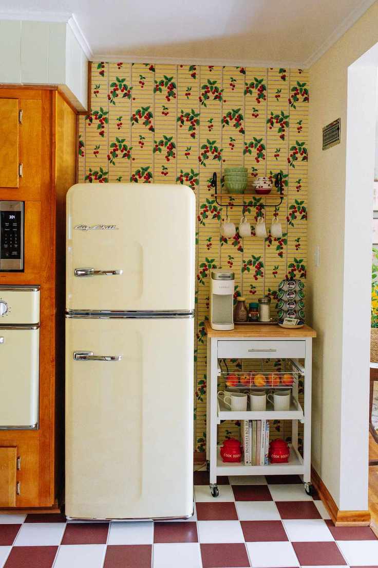 vintage kitchen with retro aesthetics featuring a vintage fridge, checkered tiles, a butler's trolley, and 50s style wallpaper