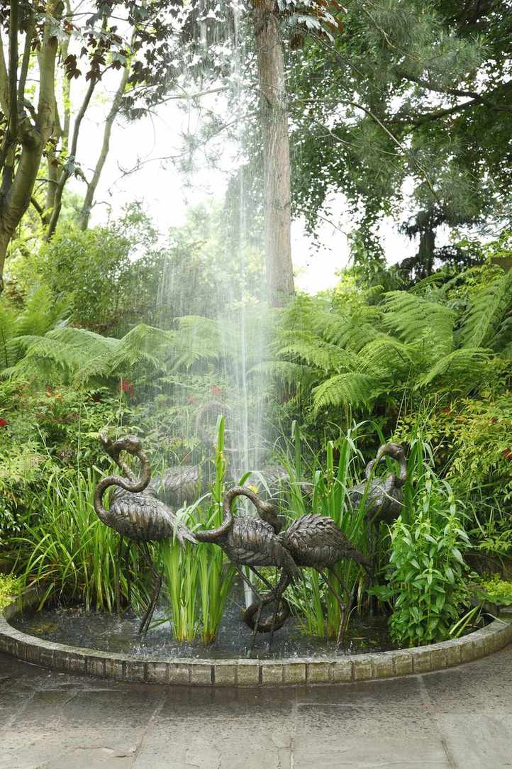 Island pond with water feature and bronze flamingoes