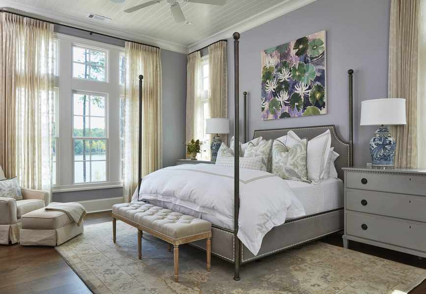 An example of how to design a bedroom showing a bedroom with a four poster bed, hardwood floor and a rug