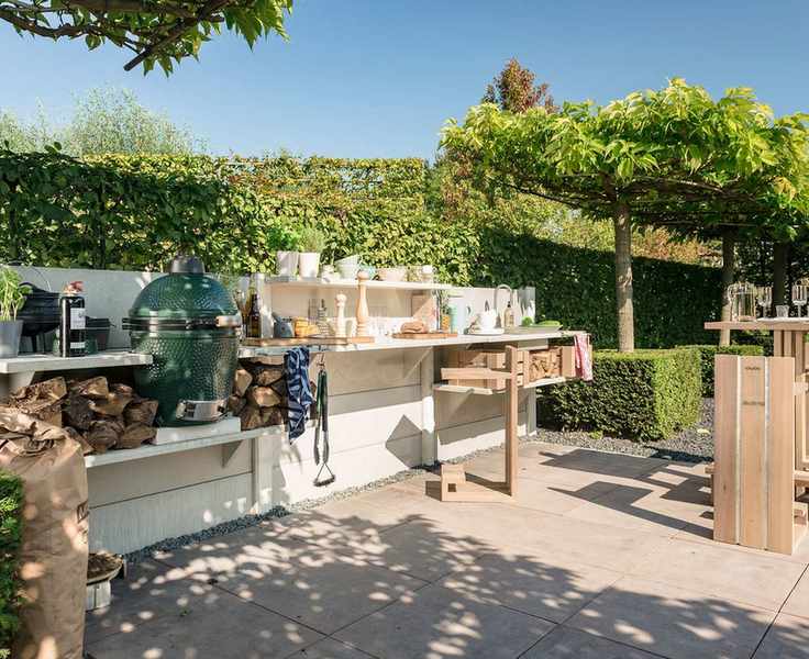 A big green egg grill in a wooden outdoor kitchen