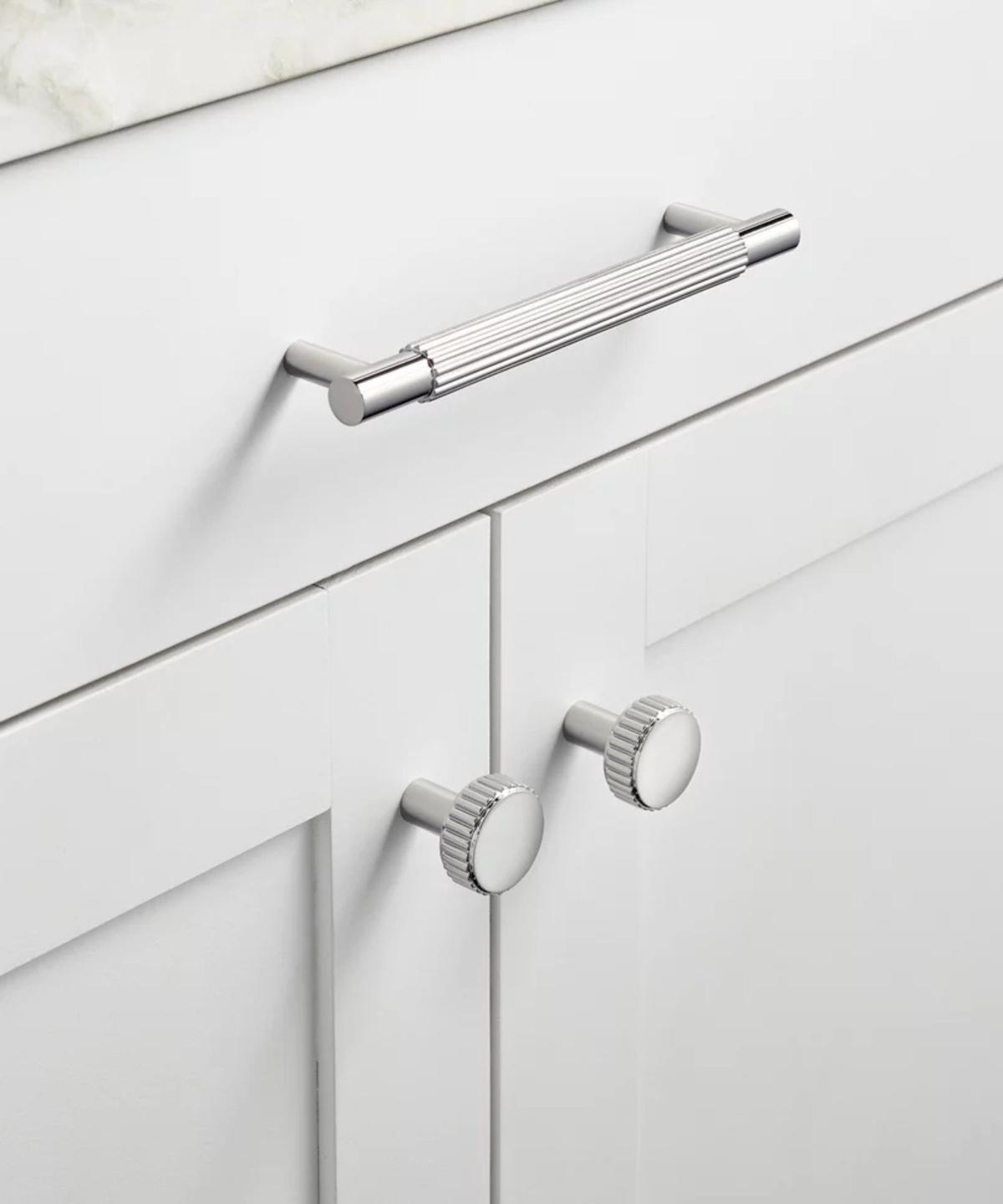 A white cabinet with silver hardware