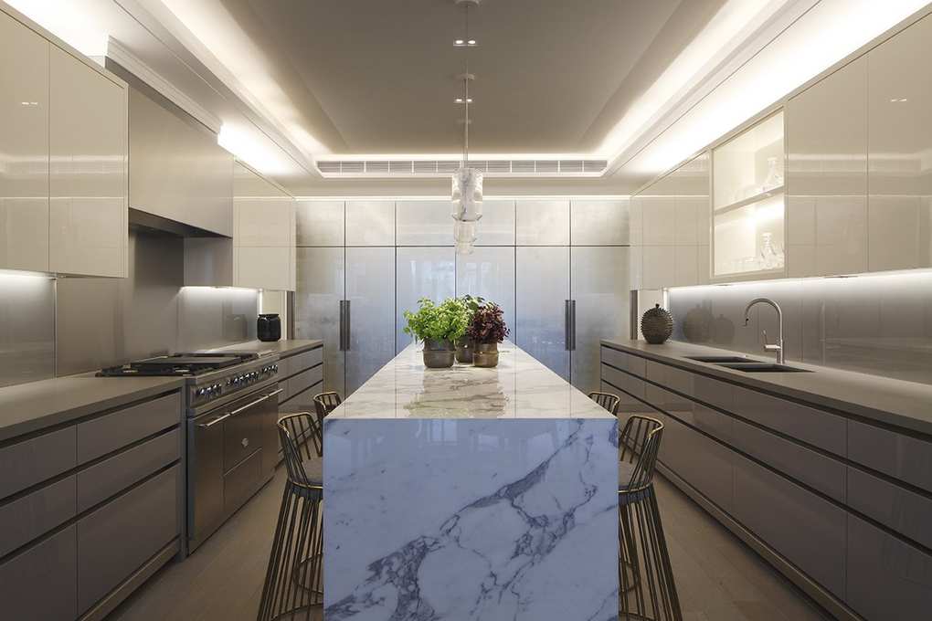 Kitchen ceiling and cabinet lighting in a modern grey kitchen with marble surfaces.