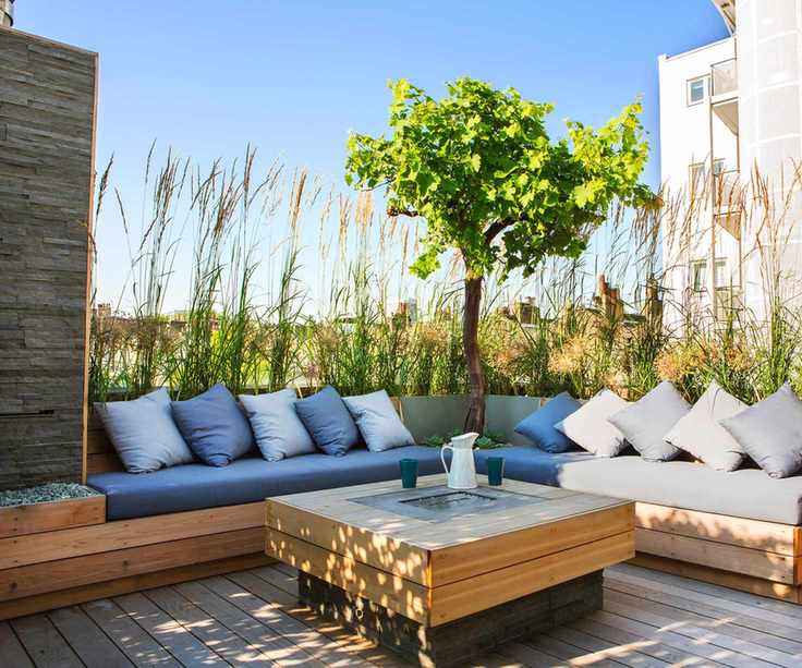 outdoor seating area on a balcony screened with ornamental grasses