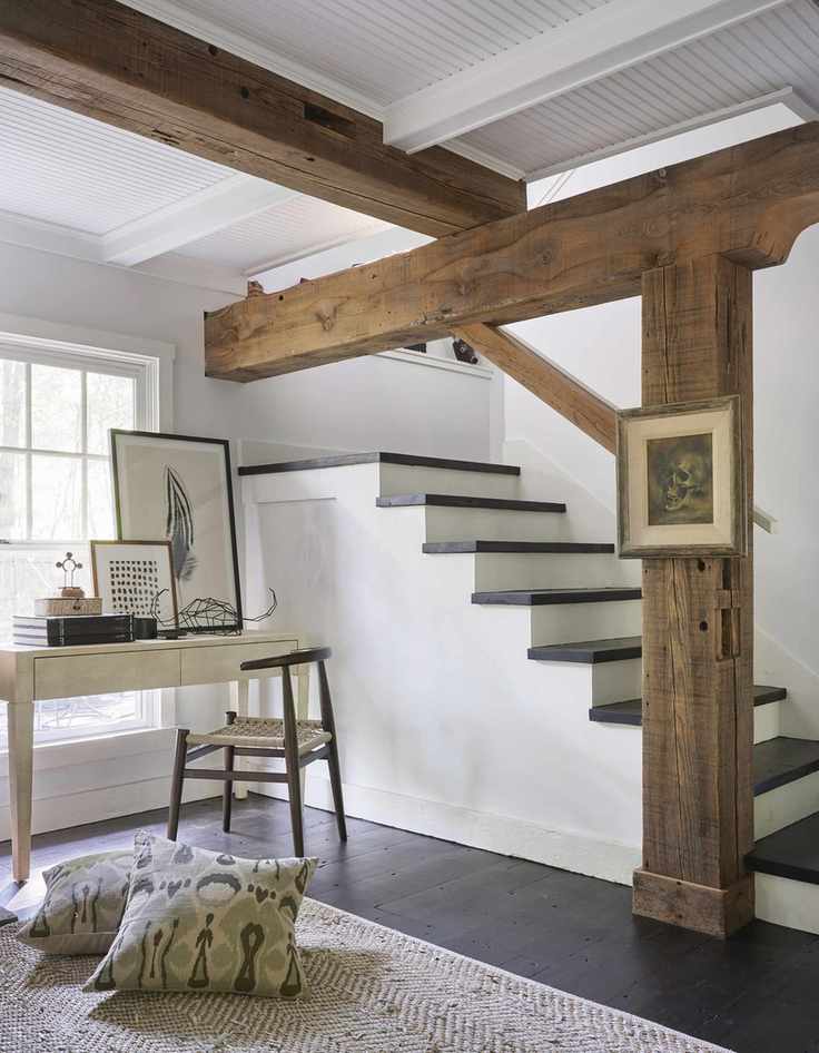 Basement with window, beams, dark wood floor, stairs down, desk and chair