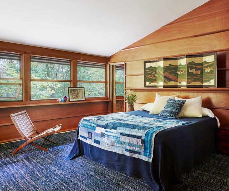 Midcentury bedroom with blue quilt and bedding, antique print and wood panelling