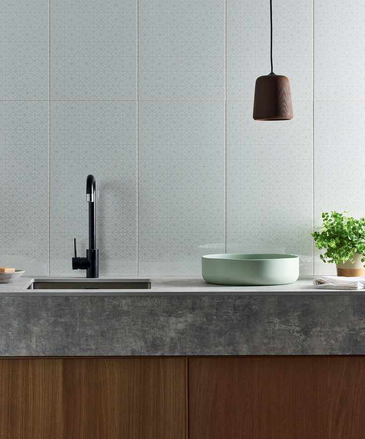 Large white ceramic kitchen wall tile ideas with a subtle gray pattern, behind a sink and concrete countertop.