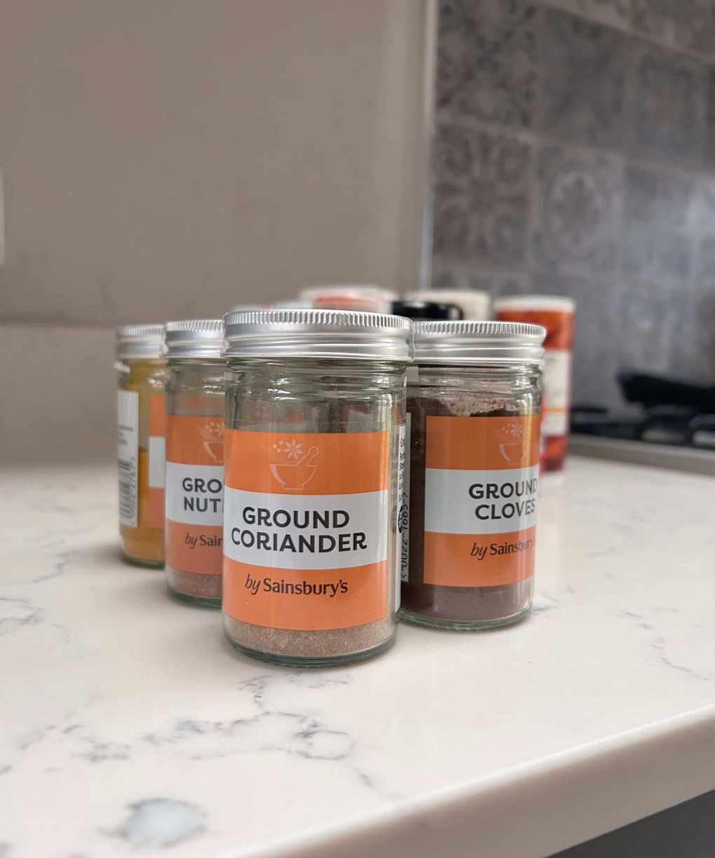 Perfectly labelled spices on a white kitchen countertop