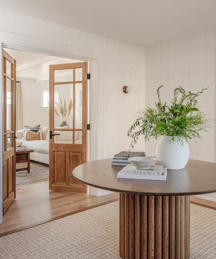 Entryway with white panelled walls and wooden accents