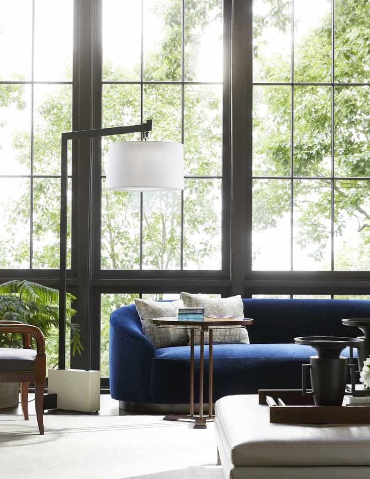 living room with blue couch, floor lamp, side table, cream carpet
