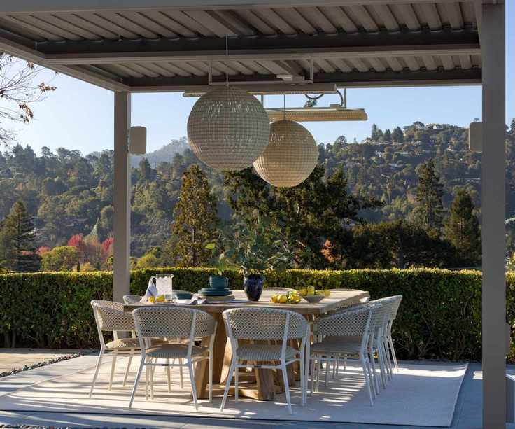 Outdoor dining table under a canopy with pendant lighting
