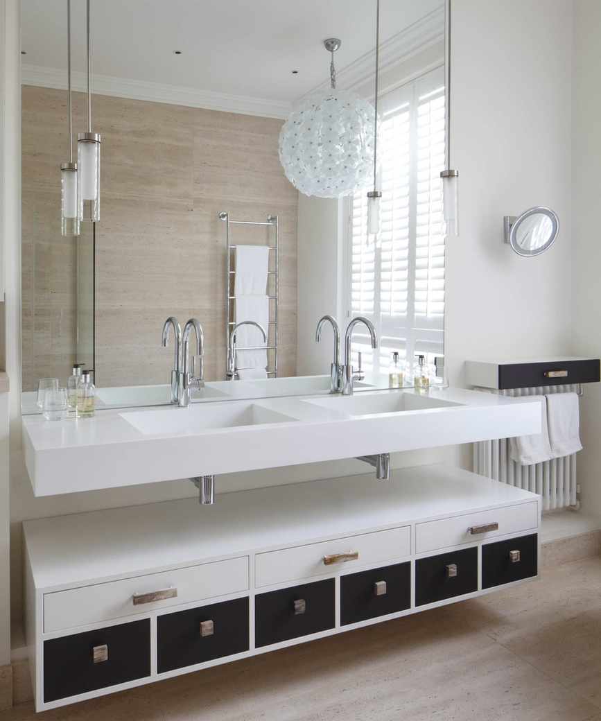 A neutral bathroom with a white double vanity, large spherical white chandelier