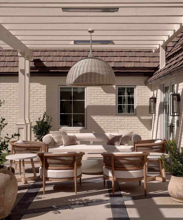 Neutral outdoor living area with pergola and rattan pendant light
