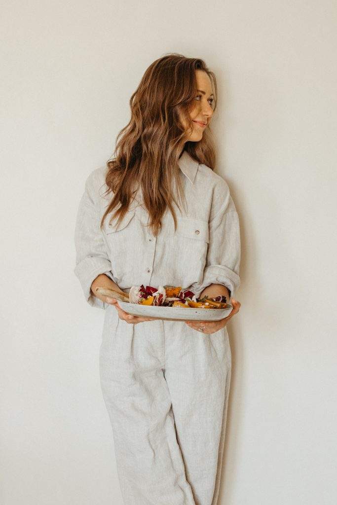Camille holding roasted honeynut squash recipe with radicchio, goat cheese and pecans
