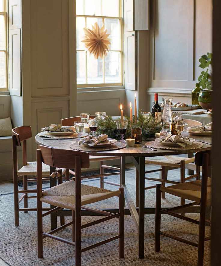 Fall table decor ideas with a round table, fabric napkins in grey, and pine centerpiece
