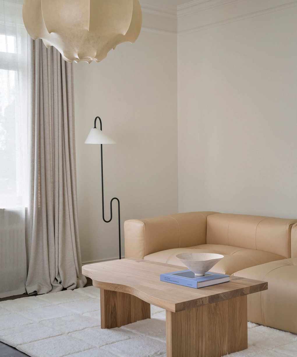 neutral living room space with layered rug and statement lampshade