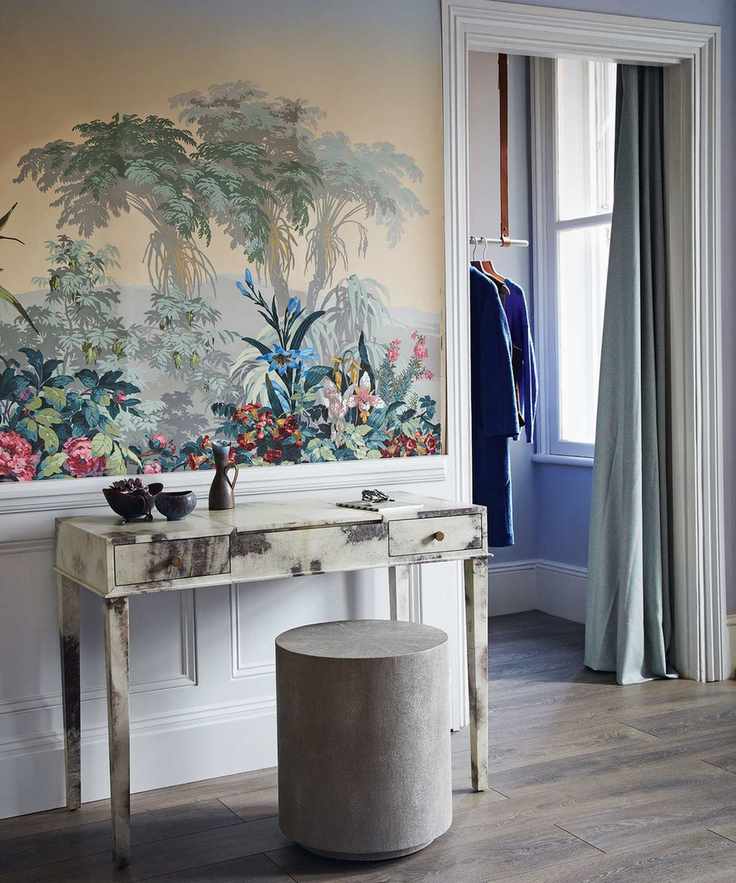 Bedroom with jungle motif wallpaper, dressing table and rounded pouffe seat, door leading to walk in closet, curtain separating the spaces