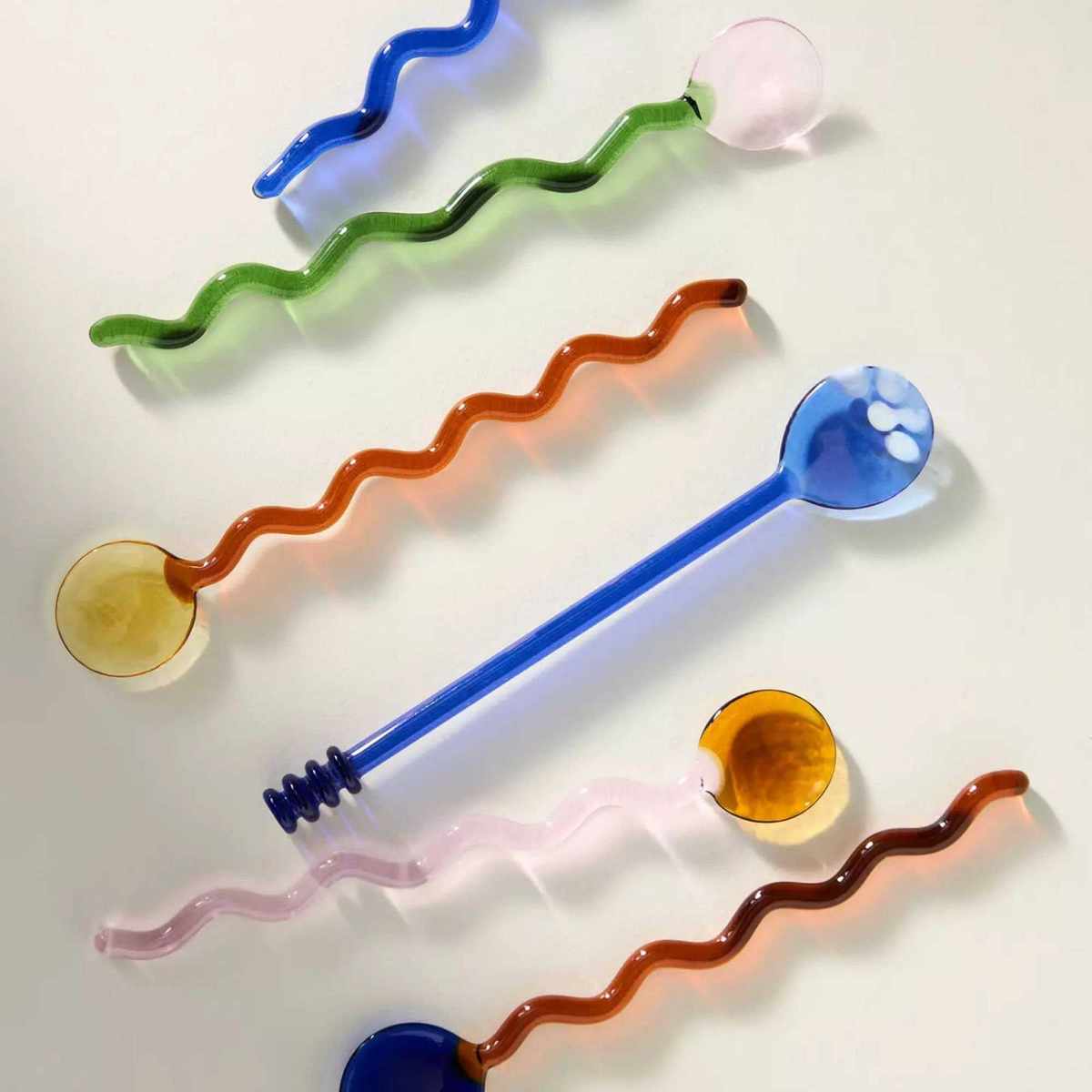 Glass spoons with wiggly handles in blue, pink, yellow and orange