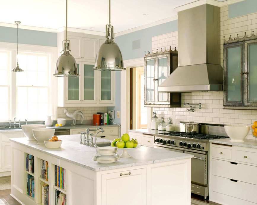 A modern kitchen with white cabinets and stylish pendant lights