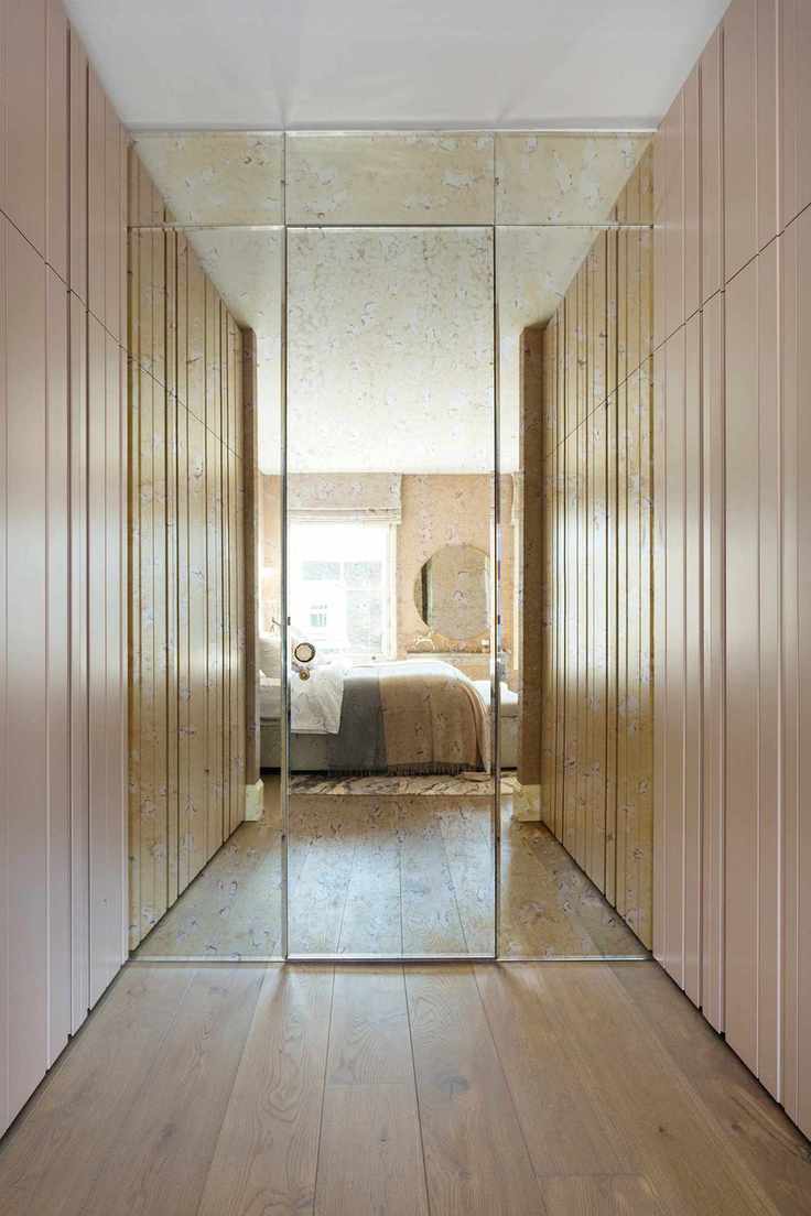 small space closet idea with vintage mirrored glass, view of bed, pink painted doors