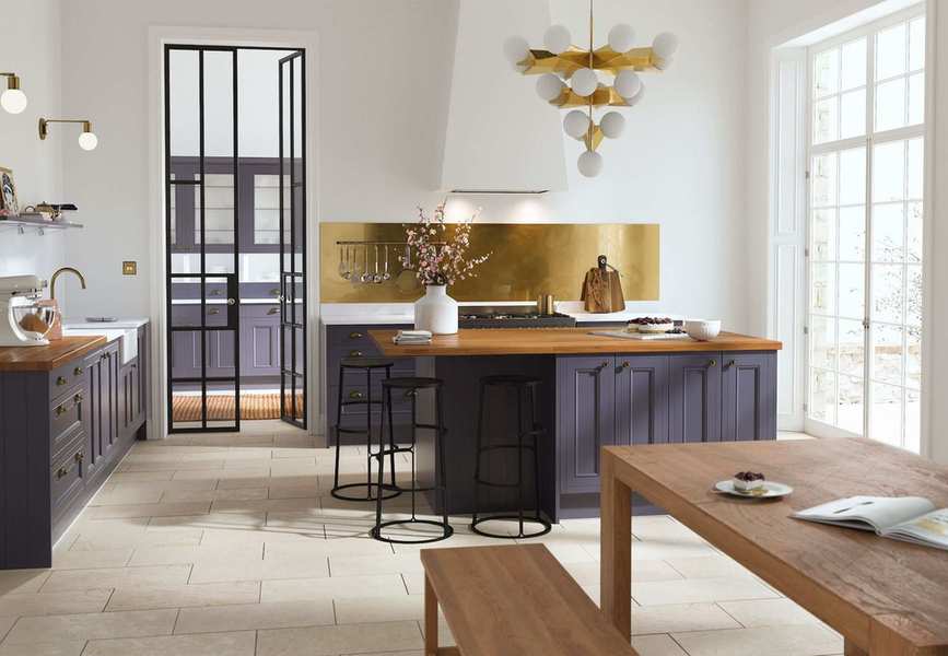 grey blue kitchen with brass splashback and brass chandelier light